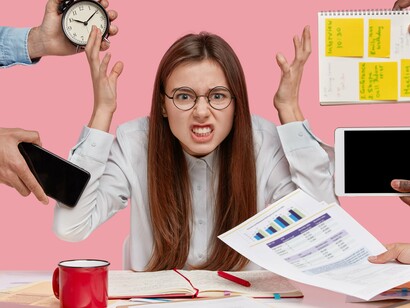 As telas e anotações acumulam exigências enquanto o corpo pede pausa. Há controvérsia entre produzir e existir