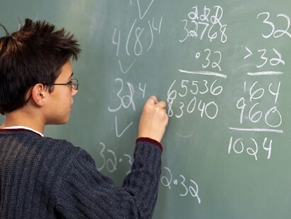 Un estudiante resuelve una operación matemática en la pizarra