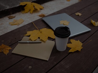 Agenda, laptop e um copo em banco 