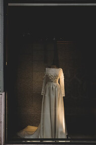 A white wedding gown on display in a haute couture boutique