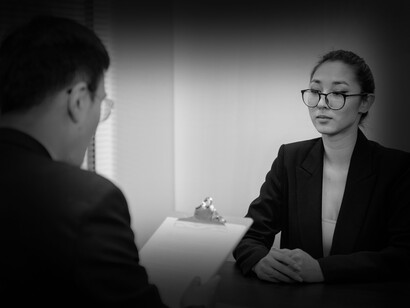 Una mujer atenta a las preguntas del encargado de recursos humanos en una entrevista