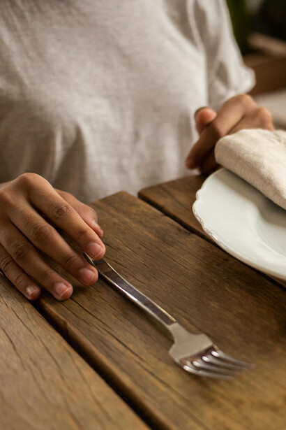 Criança posiciona garfo para cima em consonância com as regras de etiqueta