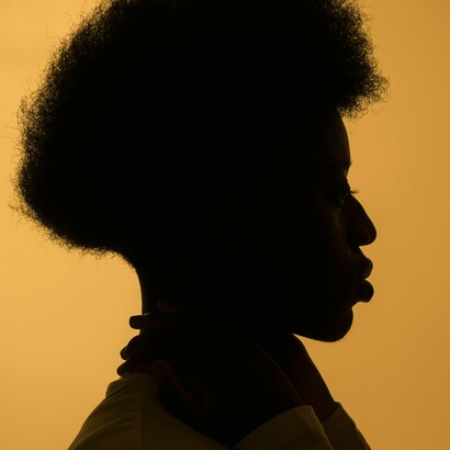 As questões não explodem; expandem-se. Crescem em ondas largas, como acontece nas mornas da cabo-verdiana Cesária Évora, onde a dor nunca sobe o volume, mas ocupa todo o espaço disponível. A repetição funciona como instrumento terapêutico: a cada retorno, a voz parece mais consciente de si e do que carrega. E as batidas – persistentes, circulares – sustentam esse transe suave que transforma a canção num espaço de recolhimento