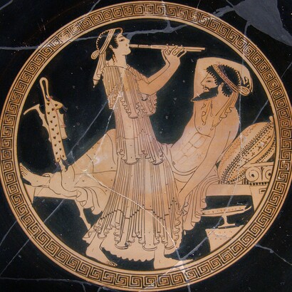 Tondo de uma taça grega de figuras vermelhas (480 a.C.): hetaira tocando o aulo