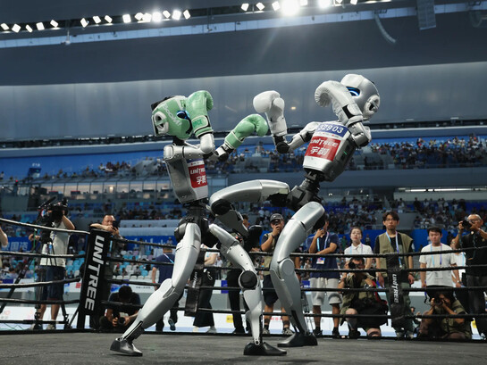 Robôs humanoides disputam uma luta de kickboxing durante os Jogos Mundiais de Robôs Humanoides, em Pequim, em agosto de 2025. O avanço da inteligência artificial e da robótica se torna também um campo de disputa sobre os modelos de sociedade e de poder que poderão moldar o futuro