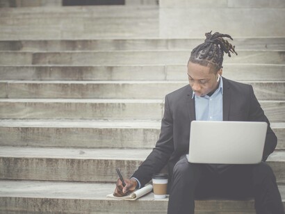 A man taking notes while surfing the net in Africa