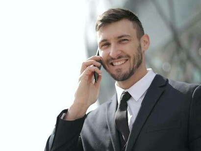 A man in a suit smiling at his recent successful call