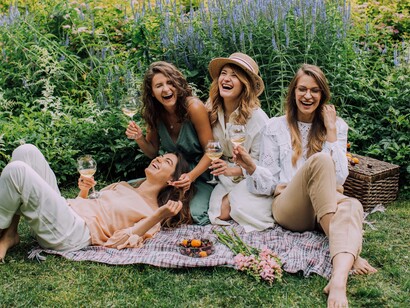 A group of friends having a picnic in a garden toasting their friendship which is not fake