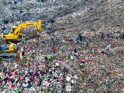 The sight of a massive garbage dump with construction equipment atop emphasizes the pressing need for robust waste management strategies, highlighting their pivotal role in mitigating environmental issues and fostering sustainable practices