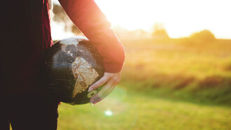 A woman with a globe in her hand represents the need for a global citizen approach to identity
