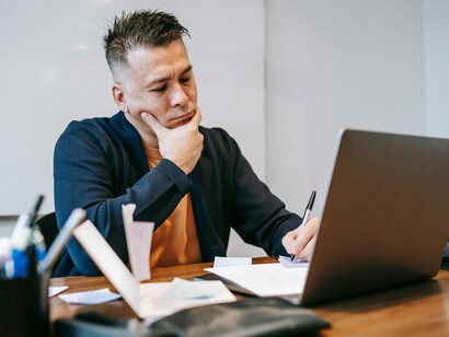 Professional man resting his fist on his chin, looking thoughtful and deep in thought