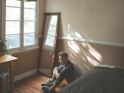 A man sitting on the floor as he feels it's the only safe place after being a victim of a crime