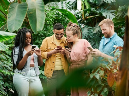 A group of friends showing each other their phones rather than interacting in real life
