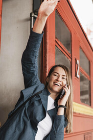 Empowered woman standing at train entrance, waving, symbolizing commitment to progress and positive change