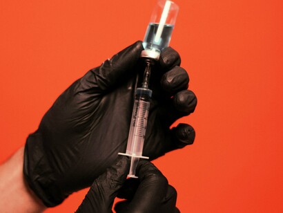 Pessoa coleta solução líquida com uma seringa. Pesquisadores continuam estudando se há uma relação direta entre a vacinação e o aumento dessas doenças ou se outros fatores, como o próprio coronavírus e o estresse pós-pandemia, estão envolvidos