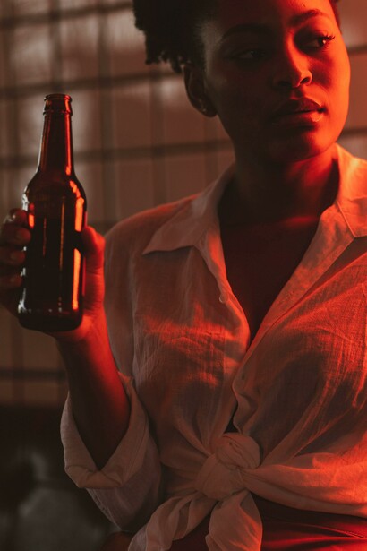 A woman in a white blouse drinking from a bottle 