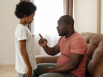 A parent and child engaged in a focused conversation, reflecting how everyday interactions shape lifelong perspectives and behaviours