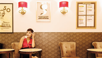 A woman drinking coffee in a cafe in Rome, Italy