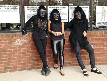 Artistas do grupo Guerrilha Girls e seu protesto ao utilizarem máscaras e roupas pretas para deslocar a ideia de que mulheres são valorizadas apenas pela beleza e forma física