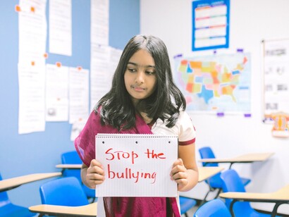 Menina segura caderno com frase 'Pare o bullying'