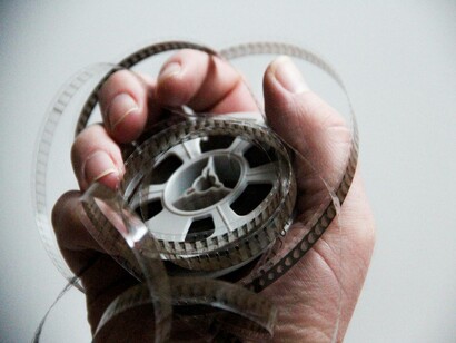 A hand holding a film reel: letting the magic of cinema take over