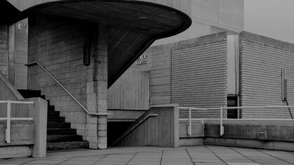 The rugged beauty of the Brutalist staircase invites reflection on the enduring legacy of concrete structures, now evolving to meet modern sustainability standards