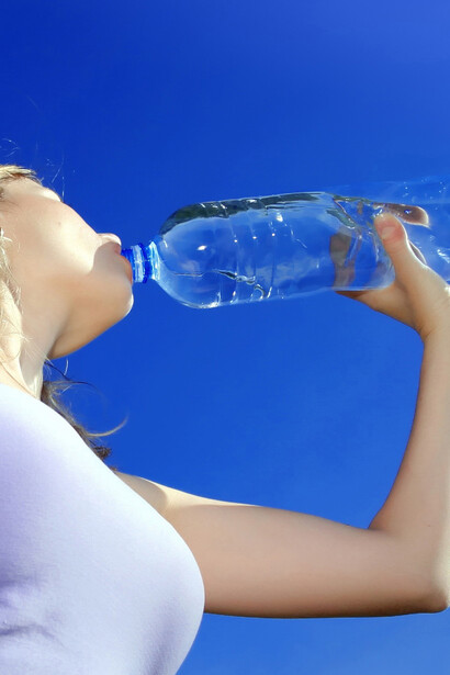 Una mujer bebiendo agua mineral