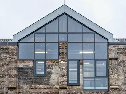 An old warehouse updated with striking glass additions, highlighting the redefinition of functional spaces