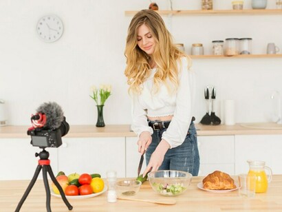 A food influencer, capturing cooking content at home, exemplifies the influence of social media on culinary culture