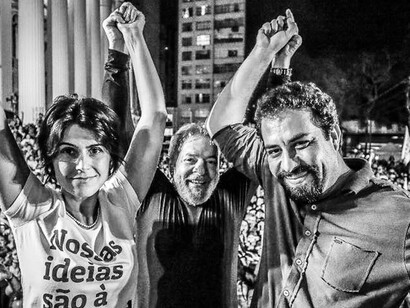Los líderes políticos Manuela d'Ávila, Luiz Inácio Lula da Silva y Guilherme Boulos levantando los brazos en alto y sonriendo ante la multitud