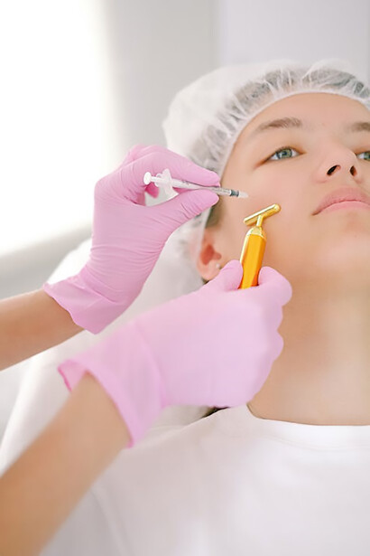 Experience youthful transformation as a young woman receives precise filler application from a doctor in pink gloves for a radiant facial enhancement