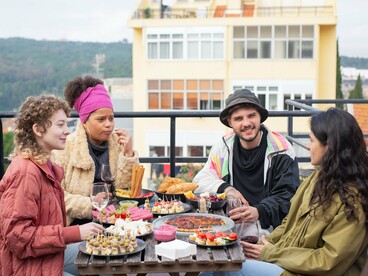 Solo travellers connecting over a communal table, reflecting the power of everyday moments to build authentic friendships