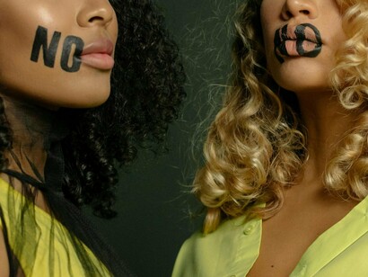Two women marked with the word “no,” reflecting the courage to protect personal limits