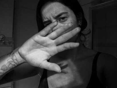 Woman hiding herself with her hand