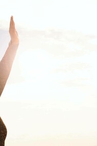 A person with arms raised greeting the limitless sky as they express they freedom