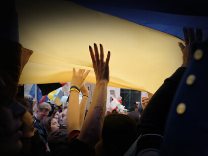 Manifestantes sostienen una bandera de Ucrania como símbolo de protesta en contra de la guerra