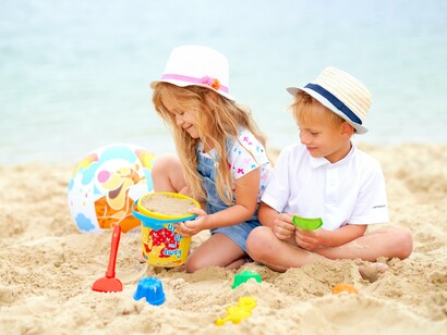 Menino e menina se divertem na areia da praia