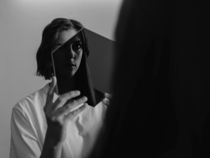 Mirrors in a woman’s hands reveal her reflected image