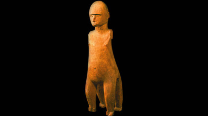 La statua del Dio Tu è una figura maschile in posizione eretta, realizzata in un unico blocco di legno scolpito ed inciso. La testa ben modellata è leggermente allungata sulla sommità ed appare totalmente calva. Il volto presenta alcuni tratti caratteristici: gli occhi sono caratterizzati dal taglio inferiore semilunato a rilievo, il naso lungo e dritto. La bocca piccola, è un ovale. Le orecchie sono staccate dalla testa e ben modellate. L’addome appare prominente rispetto alla parte superiore del corpo e la figura viene caratterizzata da due paia di gambe, uno anteriore e uno posteriore.