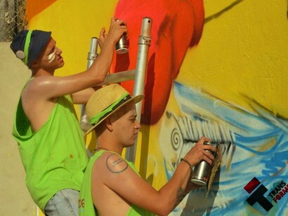 Membros do Movimento fazendo um mural em uma parede