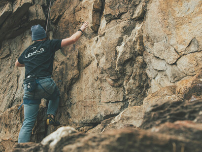 Gastonia, North Carolina, USA, a man scales a rock in safety gear, reflecting the challenge of moving beyond limits