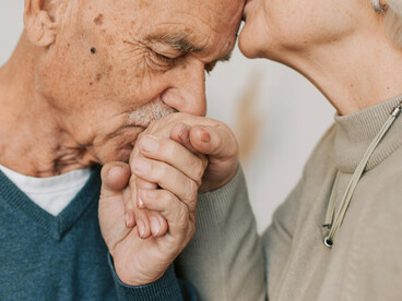 A loving elderly couple holding hands, reflecting intimacy and a deep emotional bond