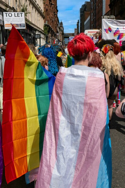 Glasgow, United Kingdom — People gathered on the street wearing rainbow flags in celebration of LGBTQ+ pride