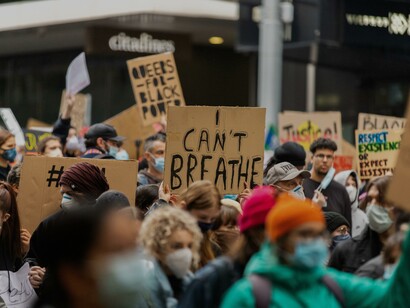 Pessoas protestando com máscaras na rua