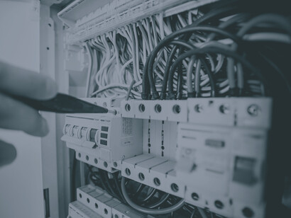 An electric panel being fine-tuned, representing the need for proper infrastructure for the functioning of the industry