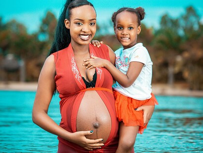 A pregnant mother and her daughter in Africa posing and representing the youth of the continent