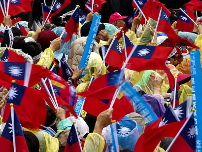 Supporters wave Taiwanese flags during a Kuomintang rally in Taiwan, reflecting the island’s deep political divisions over relations with China and the future of cross-strait relations