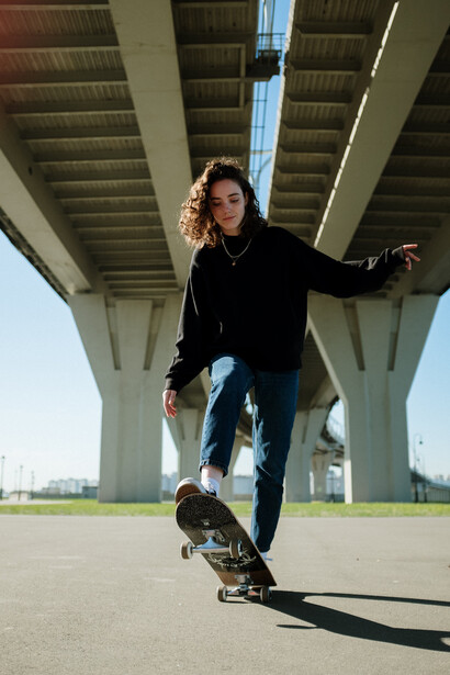 Garota skatista tenta realizar salto em cima de skate