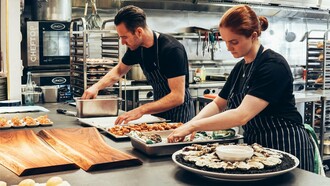 Equipe de restaurante prepara pedido. Muitos acreditam que é um trabalho que envolve muita criação de novos pratos e ideias, mas isso só é a realidade de quem comanda a cozinha, não de seus cozinheiros