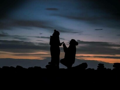 A man going down on bended knee as he prepares to deliver his marriage proposal